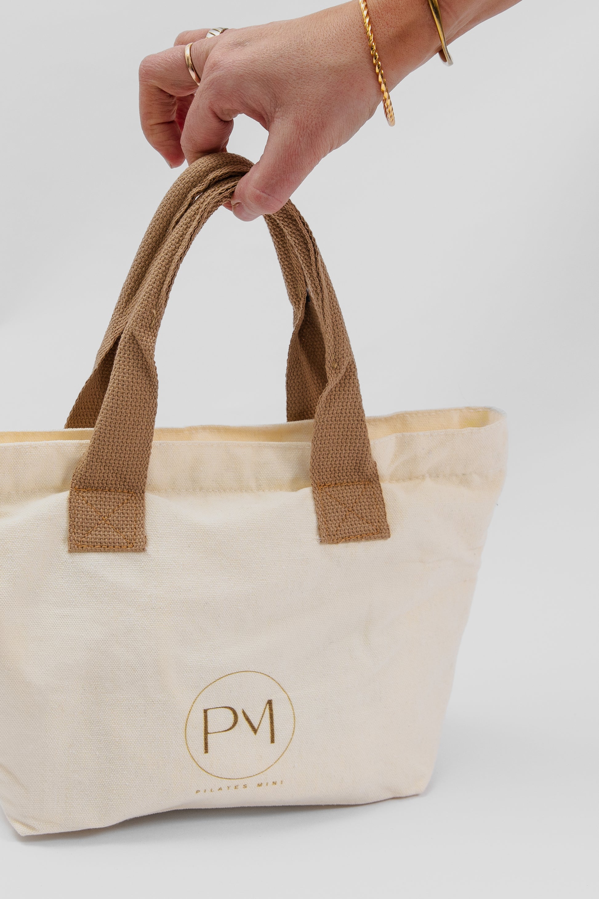 Beige tote bag with brown handles for pilates mini resistance bands travel kit
