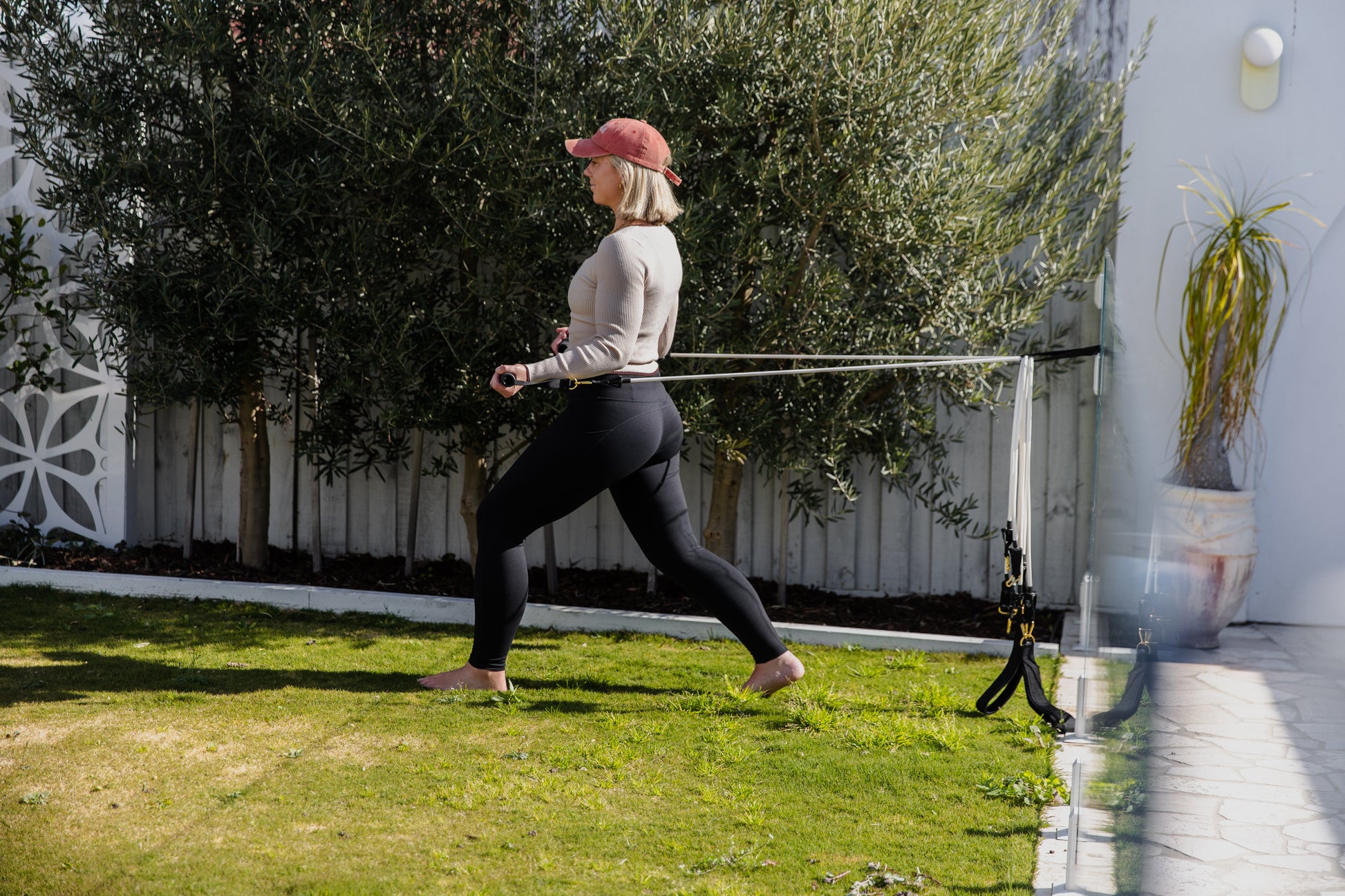 Woman do excercise in backyard lawn with resistance band pilates mini travel kit