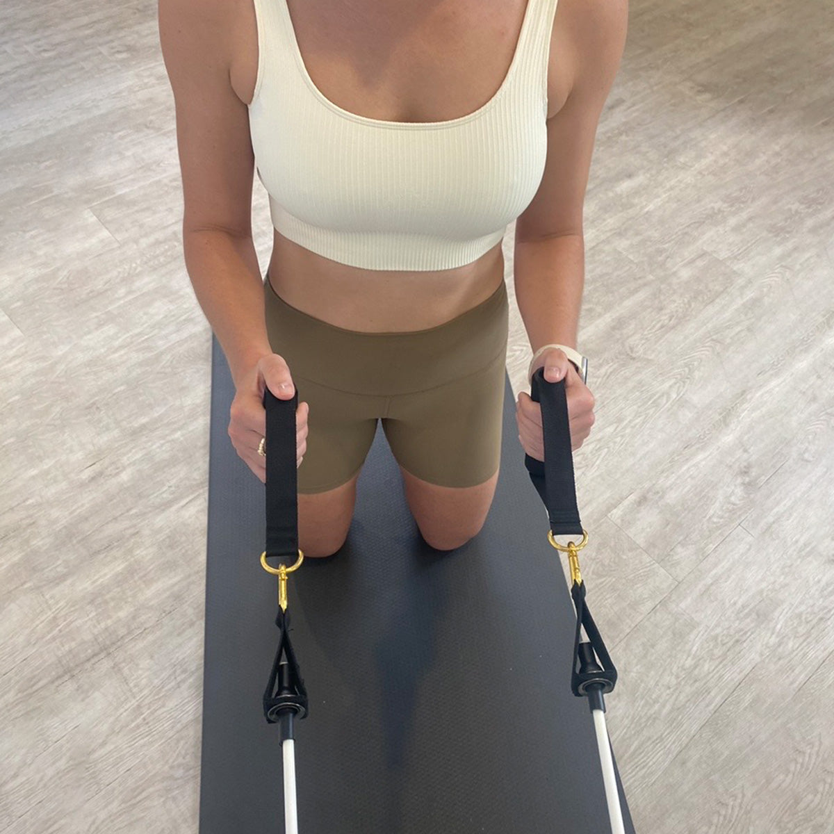 a woman using resistance bands on a mat in a home setting