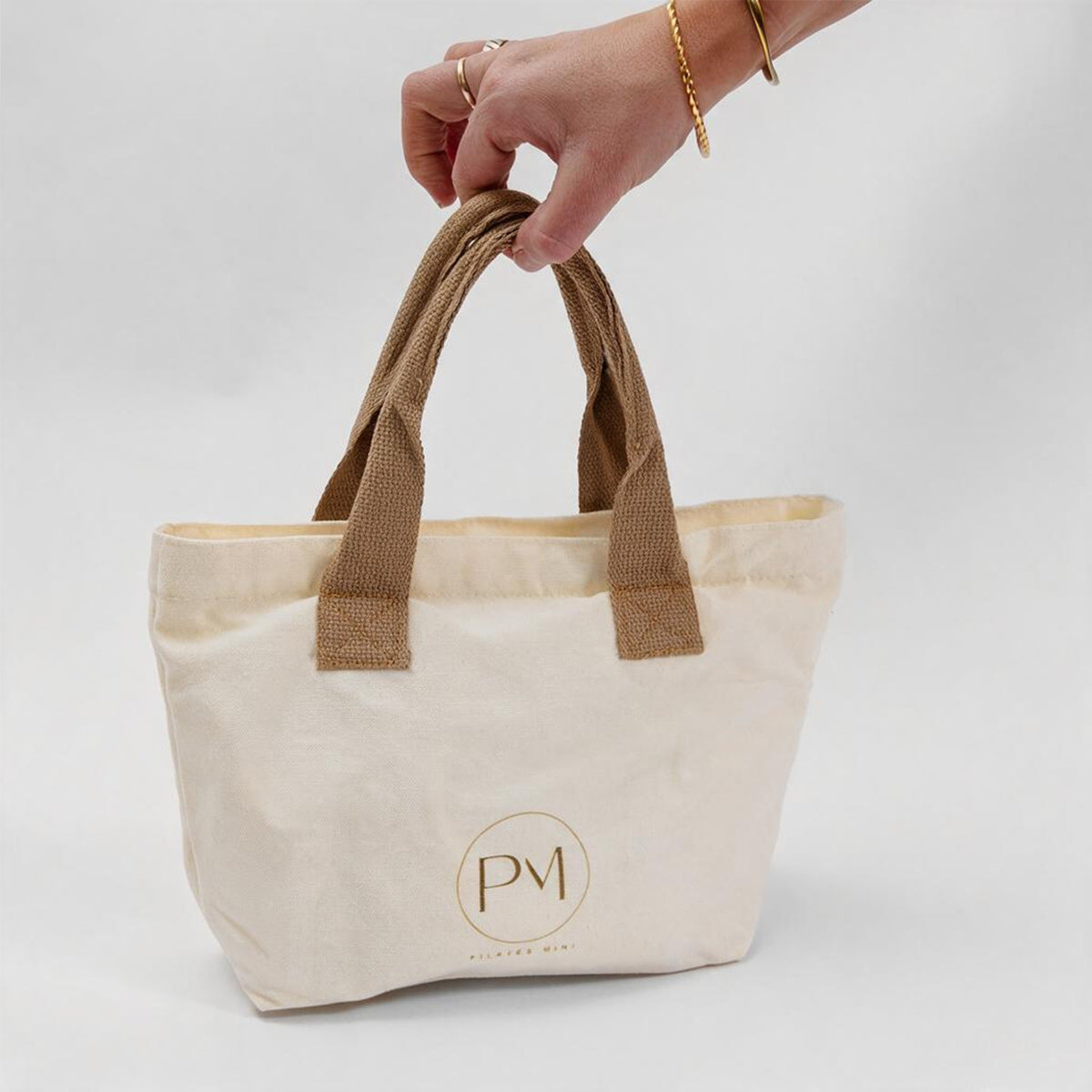 Beige tote bag with brown handles for pilates mini resistance bands travel kit