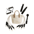 A fitness resistance band set with a beige canvas tote bag, white resistance tubes, black handles, and gold-tone metal clips, arranged on a white background.