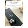 Black Pilates mat with white sneakers and black bottle on a light wooden floor, with text overlay about an accountability Pilates Mini Journal