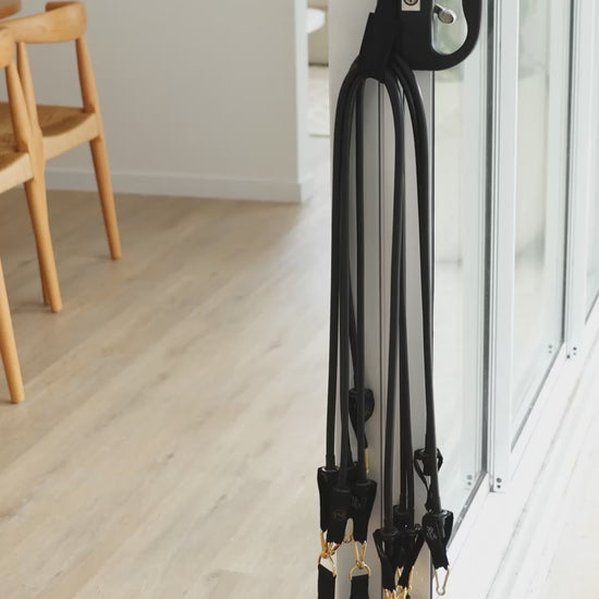 A video shows the black resistance bands Pilates mini travel kit ready for use
